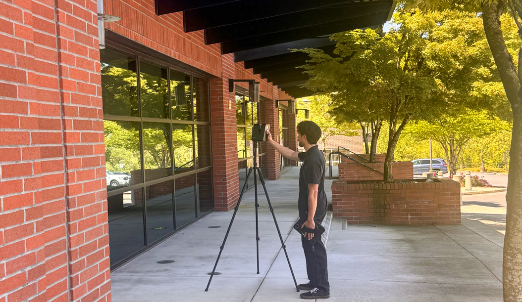 man outside of building conducting surveying duties